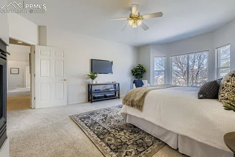 a spacious bedroom with a bed a window and a flat screen television