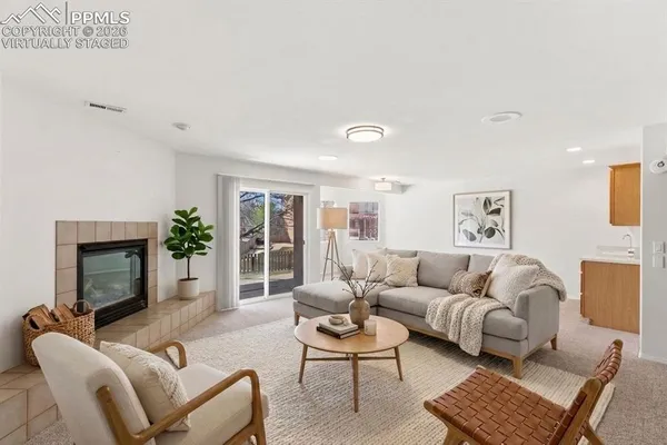 a living room with furniture a fireplace and a potted plant