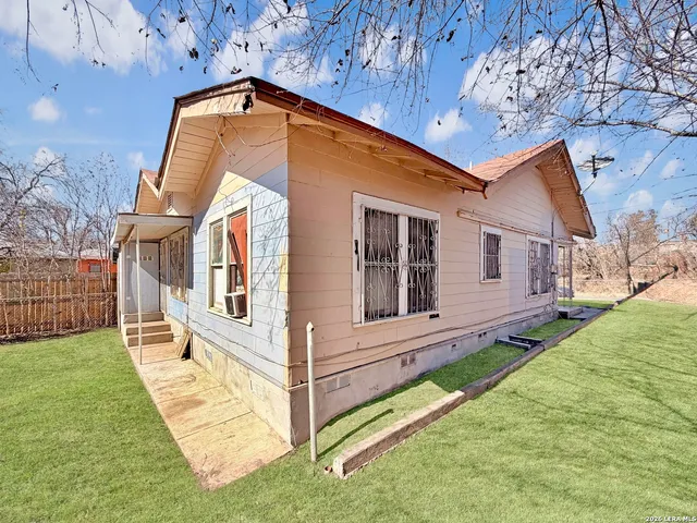 a view of a house with a big yard and large trees