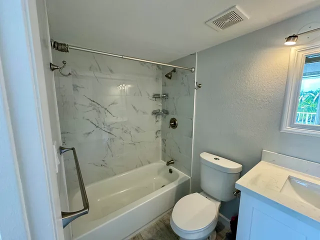 a kitchen with stainless steel appliances a microwave a stove a refrigerator a sink dishwasher with a dining table and chairs