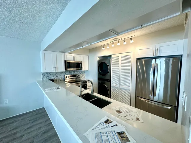 a kitchen with a refrigerator a washer and dryer