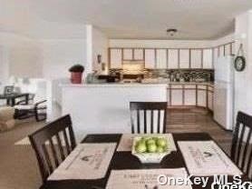 a kitchen with stainless steel appliances kitchen island granite countertop a refrigerator and a white cabinets