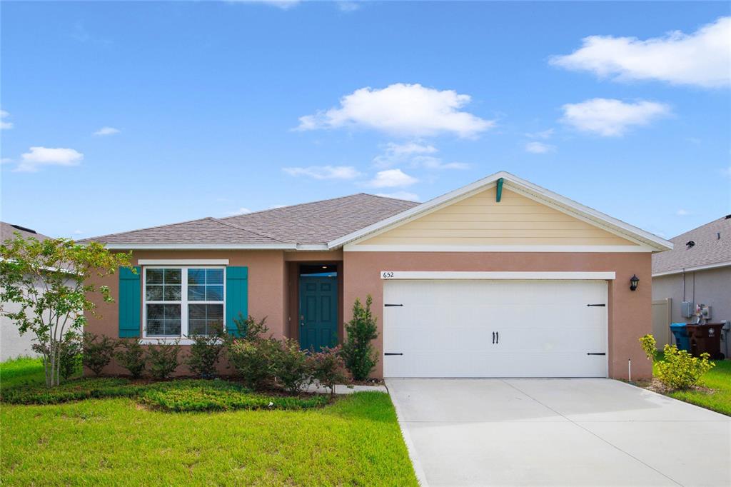 652 Greymount Street Davenport, FL 33837 - Photo 1 of 30 a view of a house with a yard and potted plants