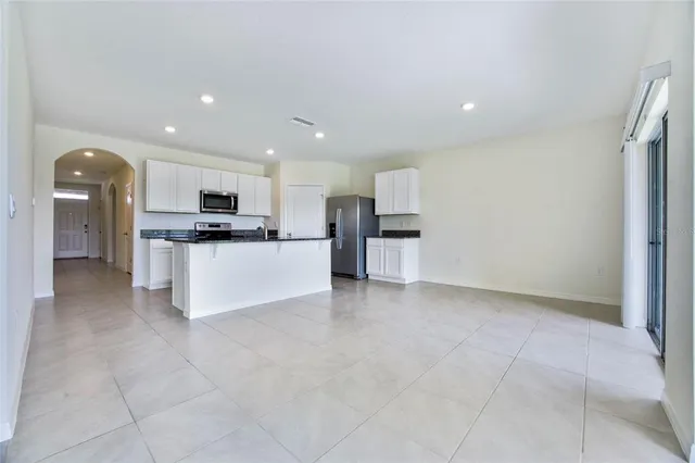 a large kitchen with stainless steel appliances a refrigerator and a stove top oven