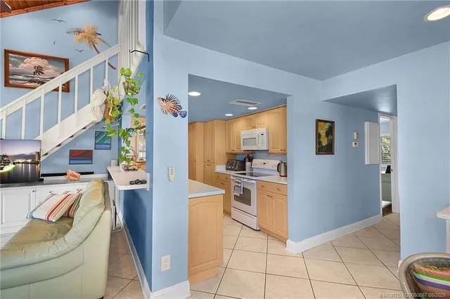 a kitchen that has a sink and a stove with white walls