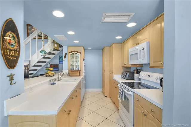 a kitchen that has a lot of cabinets in it and wooden floors