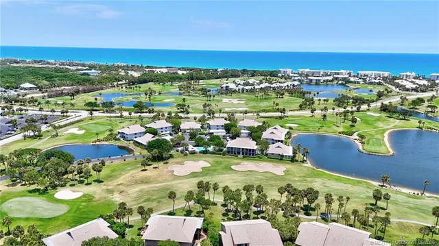 an aerial view of a house with a garden and lake view
