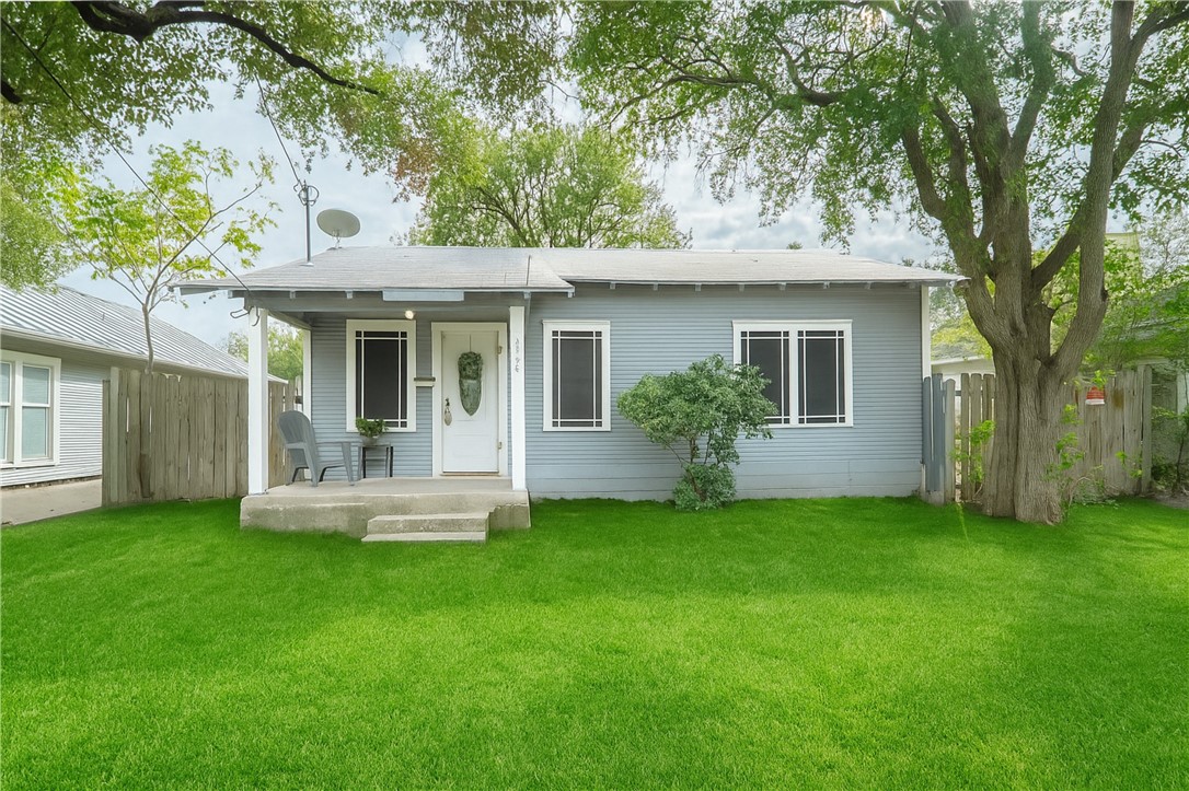 a front view of a house with a yard and trees