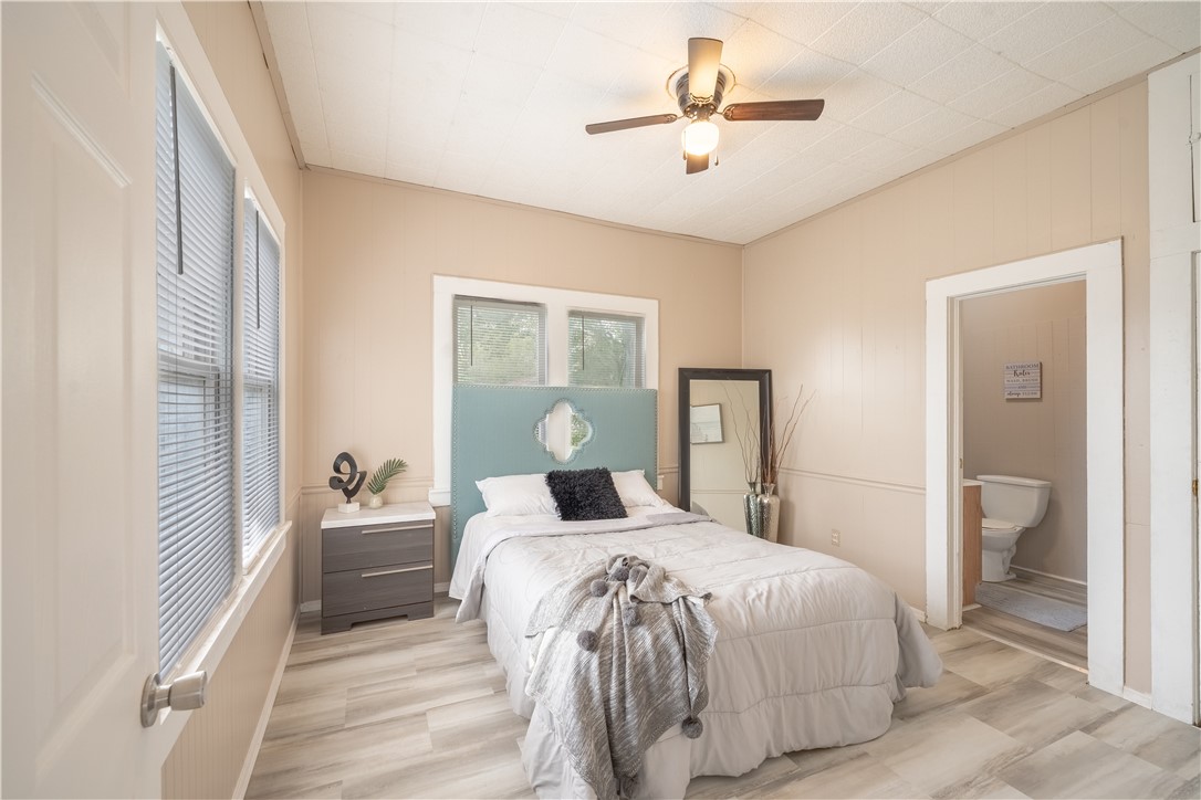 504 East 5th Street Alice, TX 78332 - Photo 6 of 12 a bedroom with a large bed and a chandelier
