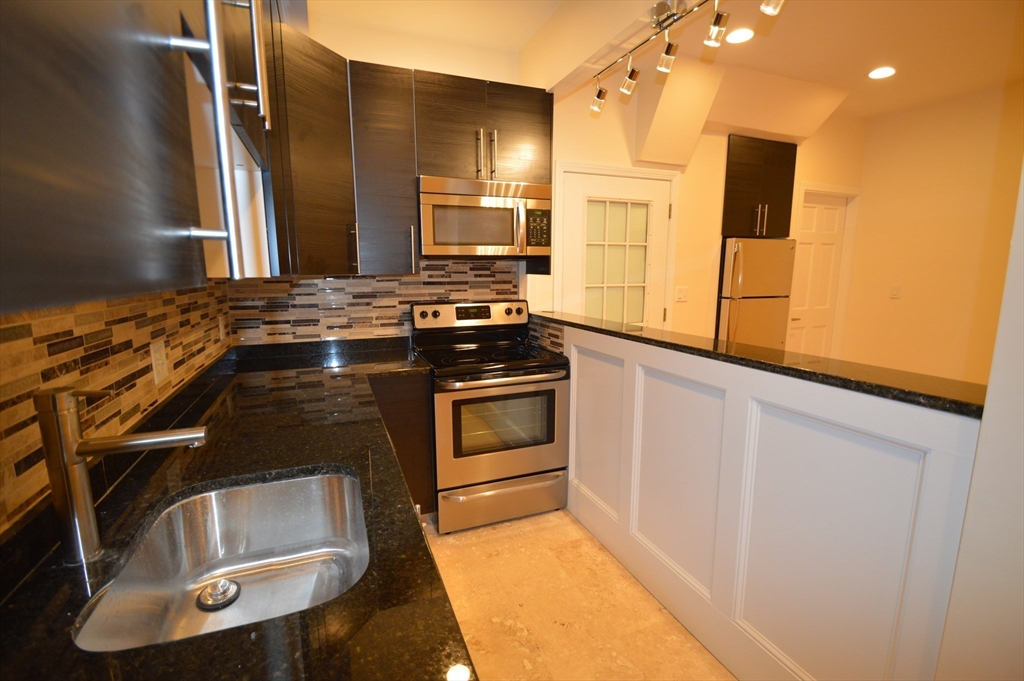 1801 Beacon Street, Unit 4 Brookline, MA 02445 - Photo 5 of 9 a kitchen with a stove and a refrigerator