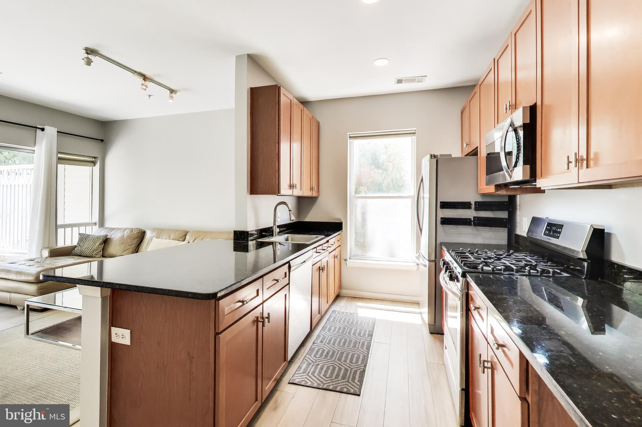 8045 Newell Street, Unit 118 Silver Spring, MD 20910 - Photo 16 of 39 a kitchen with stainless steel appliances granite countertop a stove a sink dishwasher and a refrigerator