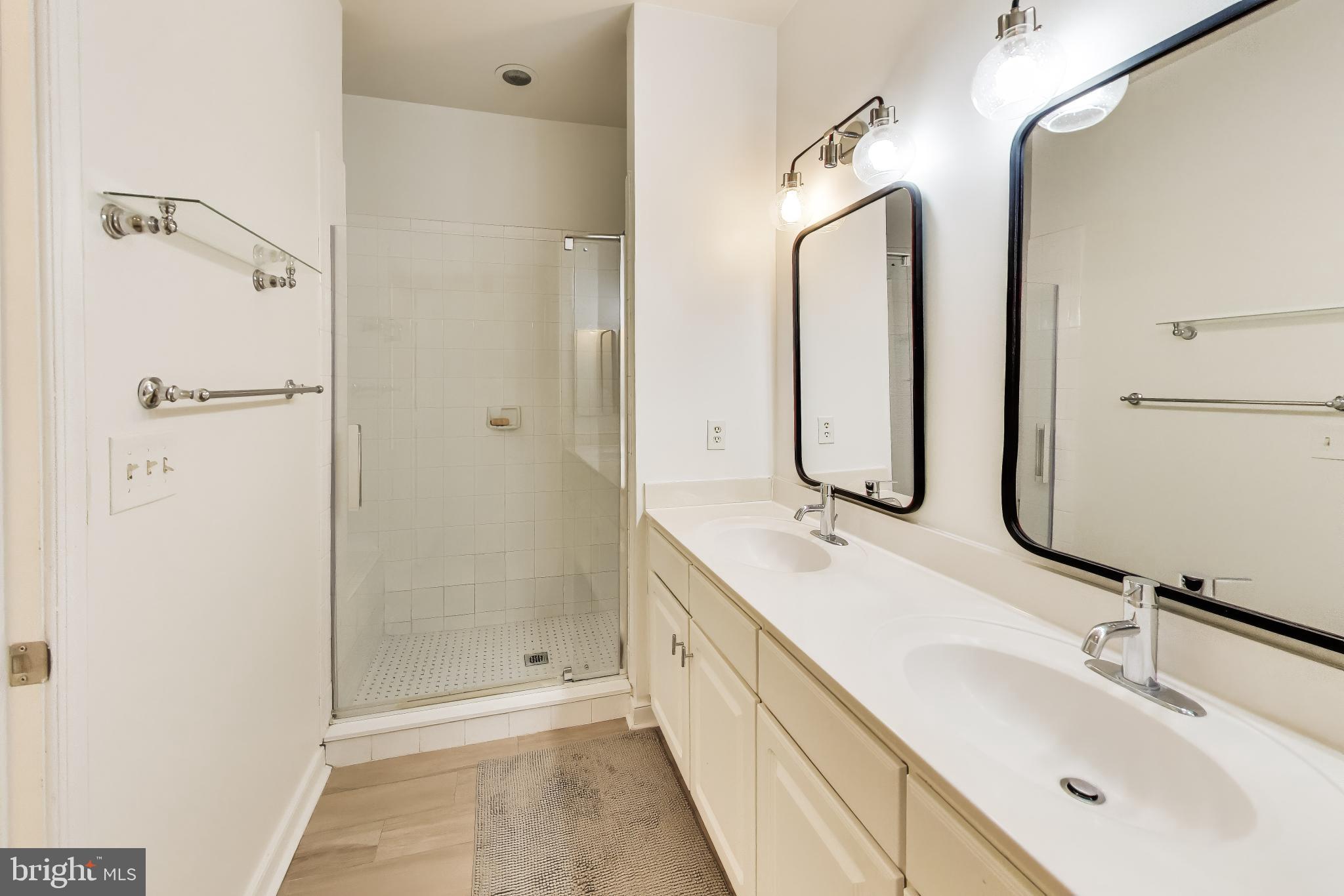 8045 Newell Street, Unit 118 Silver Spring, MD 20910 - Photo 23 of 39 a bathroom with a double vanity sink mirror and shower