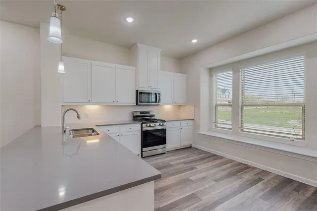 a large kitchen with a large window and stainless steel appliances