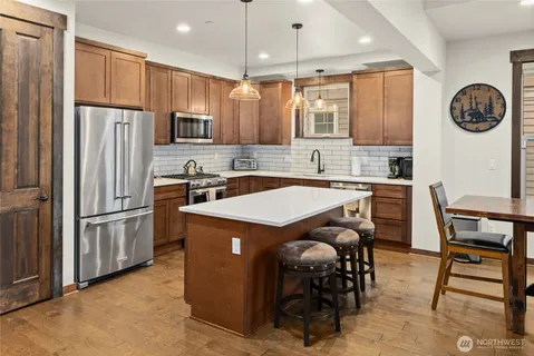 a kitchen with stainless steel appliances granite countertop a refrigerator a stove a sink and a refrigerator
