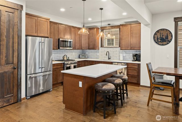 a kitchen with stainless steel appliances granite countertop a refrigerator a stove a sink and a refrigerator