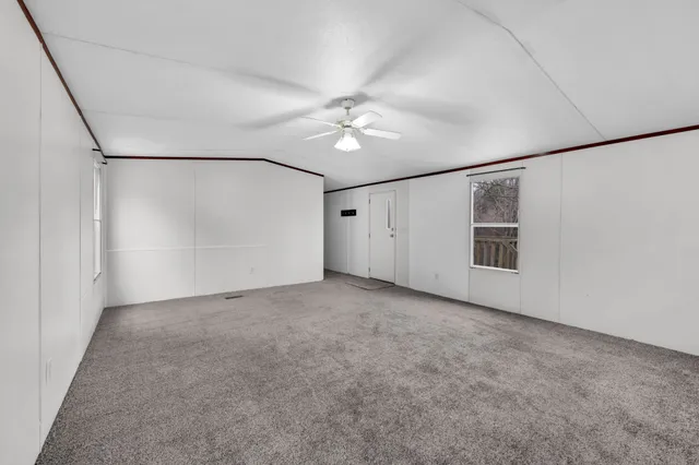 a view of a big room with ceiling fan and refrigerator