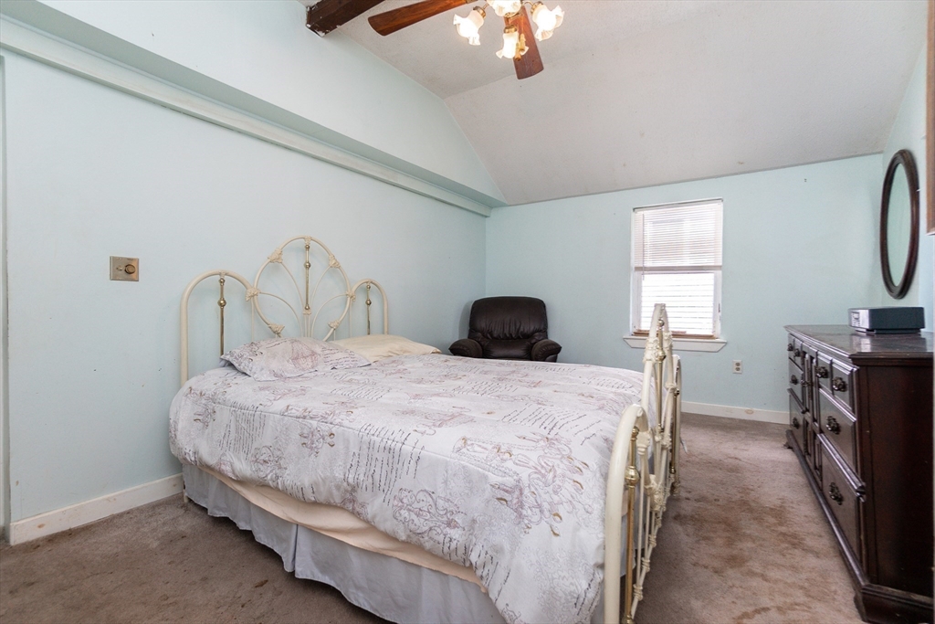 9 Barton Street Salem, MA 01970 - Photo 12 of 26 a bedroom with a bed a chandelier and dresser
