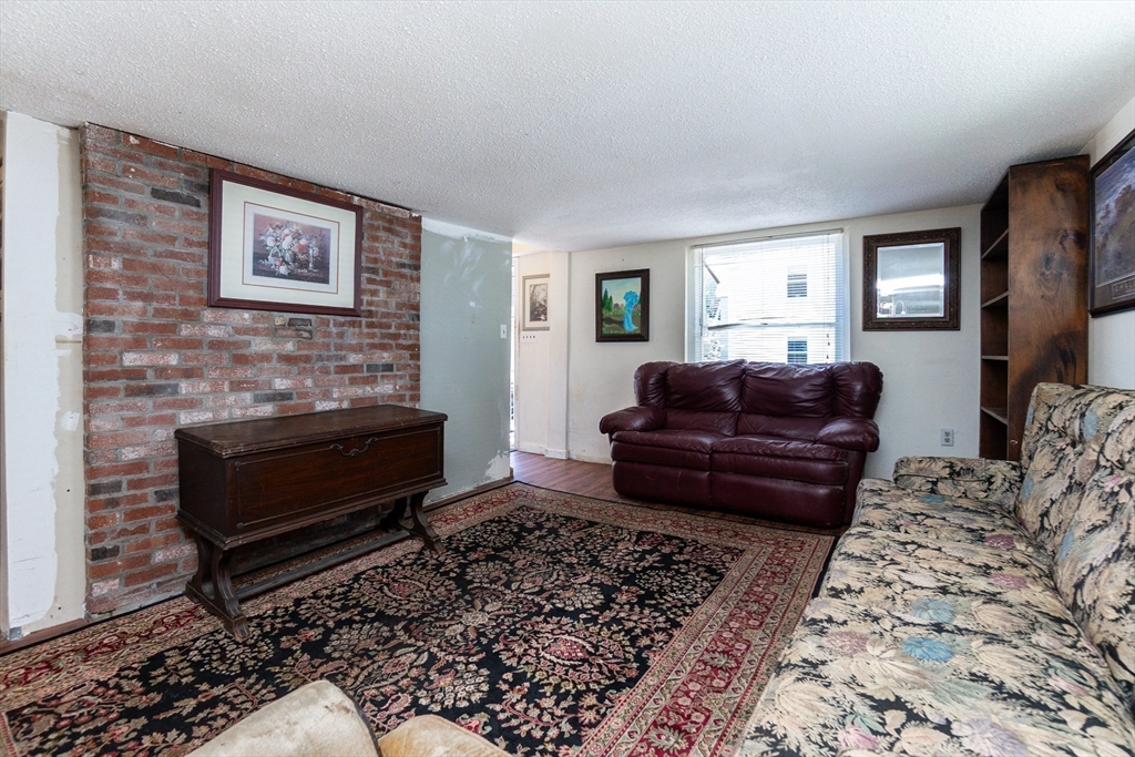 9 Barton Street Salem, MA 01970 - Photo 4 of 26 a living room with furniture a couch and two windows