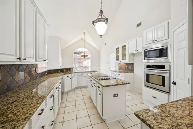 a kitchen with stainless steel appliances kitchen island granite countertop a sink stove and cabinets