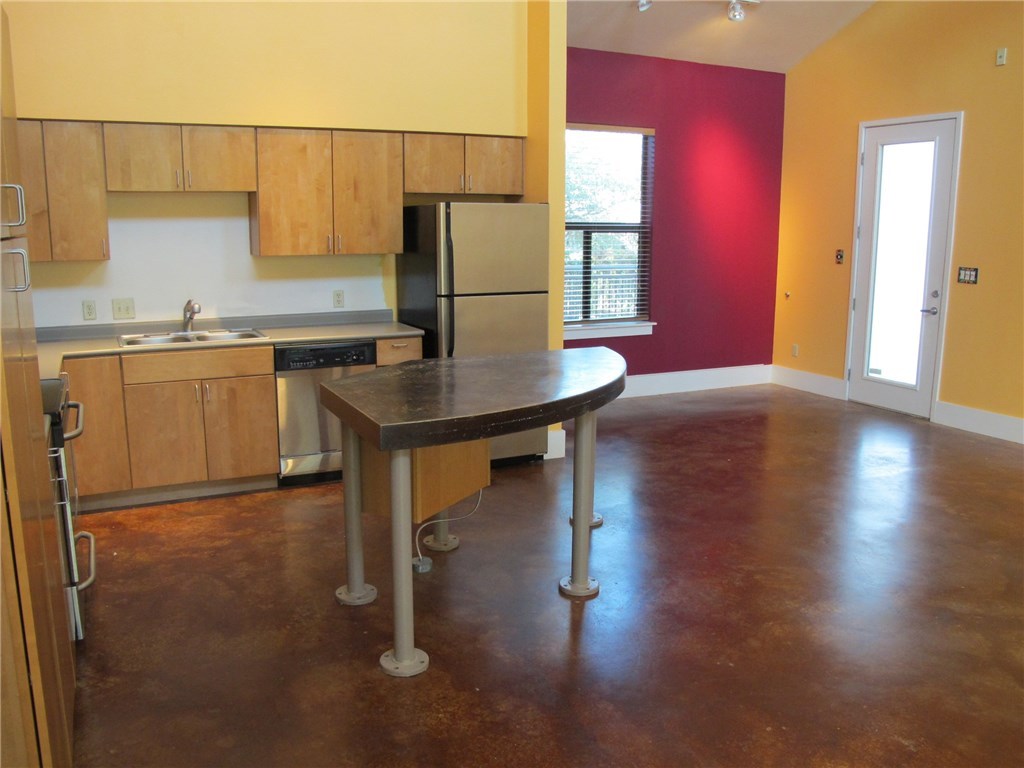 911 Keith Lane, Unit 10 Austin, TX 78705 - Photo 2 of 20 a kitchen with stainless steel appliances granite countertop a sink refrigerator and cabinets