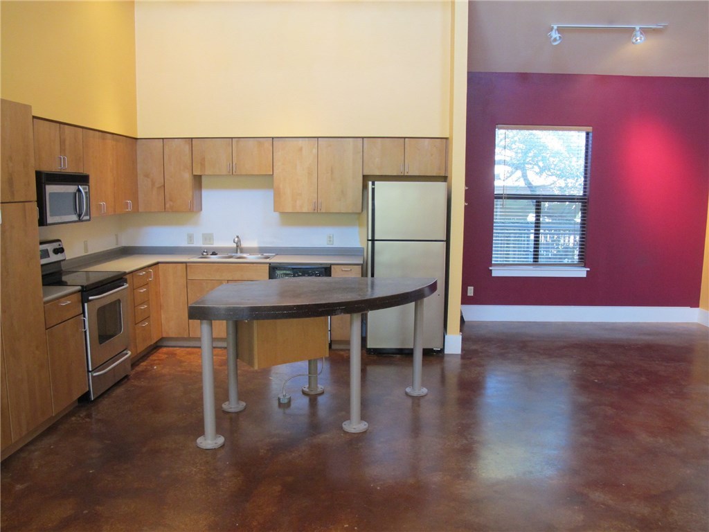 911 Keith Lane, Unit 10 Austin, TX 78705 - Photo 4 of 20 a kitchen with stainless steel appliances granite countertop a sink a stove a microwave a counter top space and cabinets