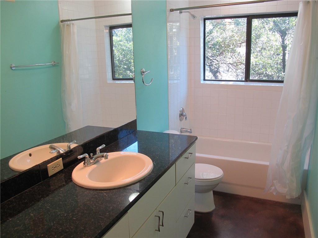 911 Keith Lane, Unit 10 Austin, TX 78705 - Photo 10 of 20 a bathroom with a sink a toilet a mirror and a tub