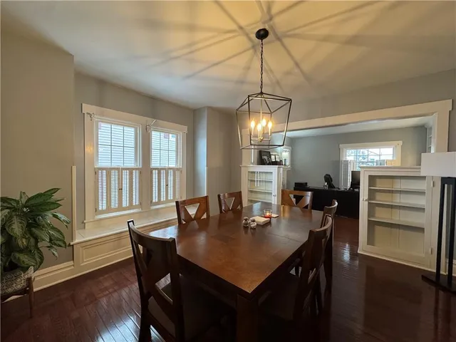 a view of a dining room and livingroom with furniture wooden floor a chandelier