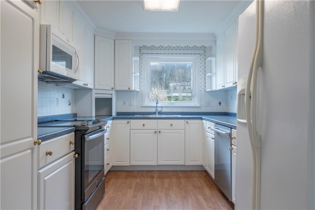 57 Shick Drive Indiana, PA 15701 - Photo 9 of 48 a kitchen with stainless steel appliances granite countertop a stove a sink and white cabinets