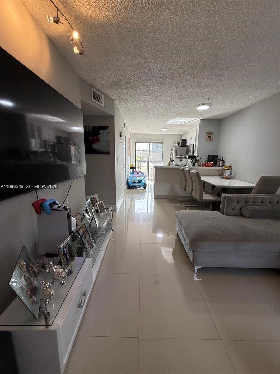 5290 West 21st Court, Unit 307 Hialeah, FL 33016 - Photo 4 of 22 a living room with furniture and a flat screen tv