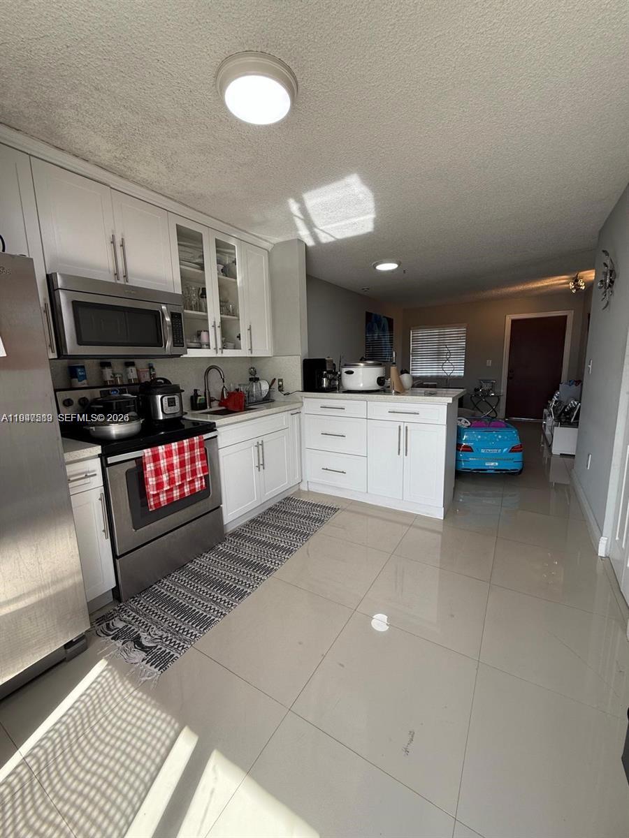 5290 West 21st Court, Unit 307 Hialeah, FL 33016 - Photo 6 of 22 a kitchen with stainless steel appliances granite countertop a sink stove and cabinets