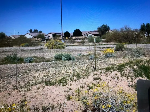 a view of a yard with wooden fence