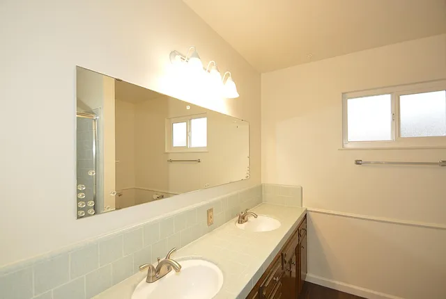 a bathroom with a granite countertop sink and a mirror