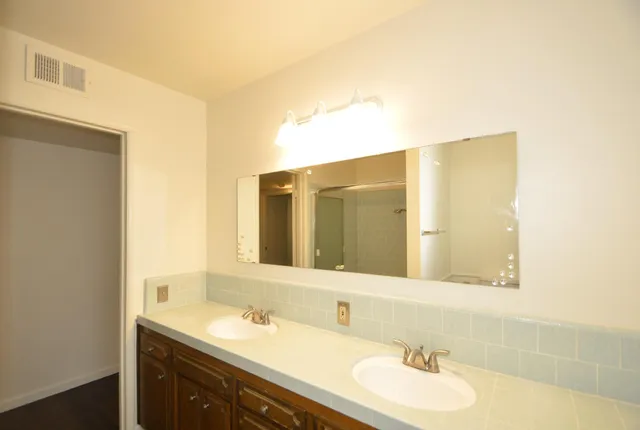 a bathroom with a granite countertop sink and a mirror