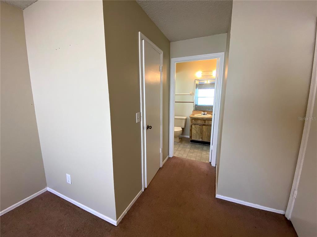 4148 Pershing Pointe Place, Unit 1 Orlando, FL 32822 - Photo 19 of 33 a view of a hallway with bedroom and closet