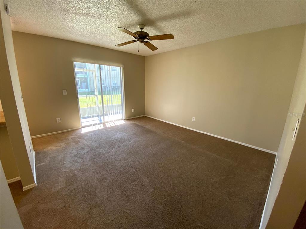 4148 Pershing Pointe Place, Unit 1 Orlando, FL 32822 - Photo 3 of 33 an empty room with a ceiling fan and windows