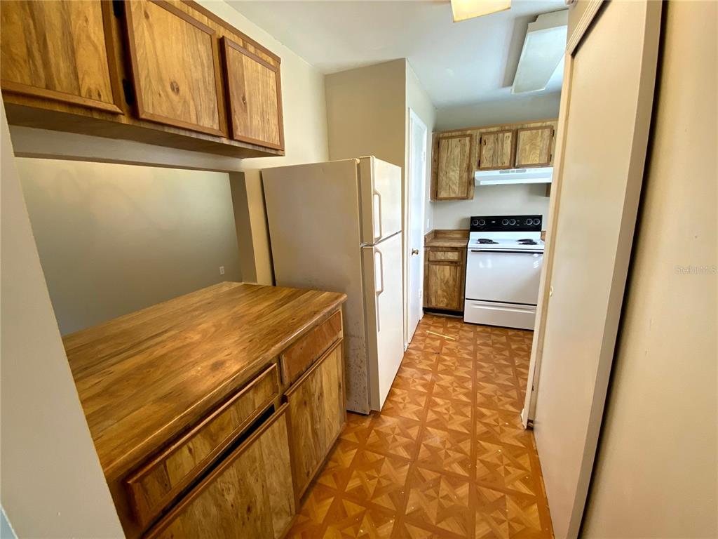 4148 Pershing Pointe Place, Unit 1 Orlando, FL 32822 - Photo 5 of 33 a kitchen with a refrigerator and a stove top oven