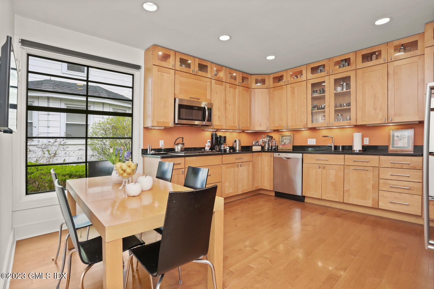 65 Ridge Street Greenwich, CT 06830 - Photo 13 of 35 a kitchen with stainless steel appliances granite countertop a stove a sink dishwasher a microwave oven with a dining table and chairs