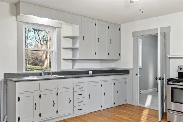 a kitchen with granite countertop white cabinets and white appliances