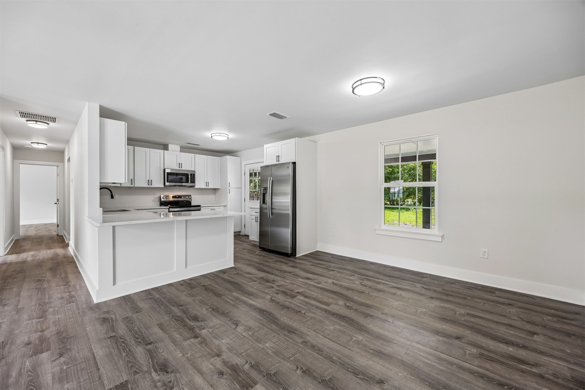 552 Sunset Road Fernandina Beach, FL 32034 - Photo 4 of 23 a kitchen with white cabinets and stainless steel appliances