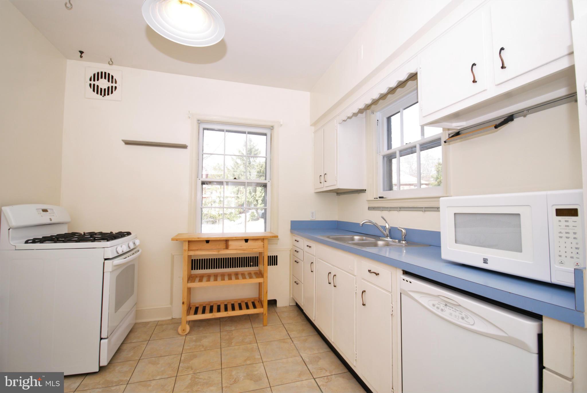 326 Paddington Road Baltimore, MD 21212 - Photo 11 of 29 a kitchen with granite countertop a stove a sink and a microwave