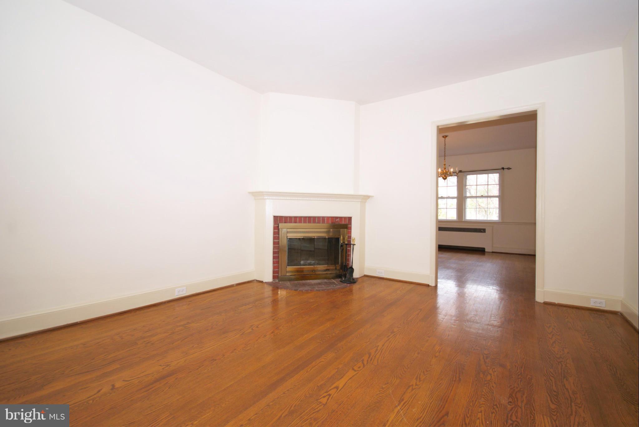 326 Paddington Road Baltimore, MD 21212 - Photo 13 of 29 an empty room with wooden floor and a fireplace