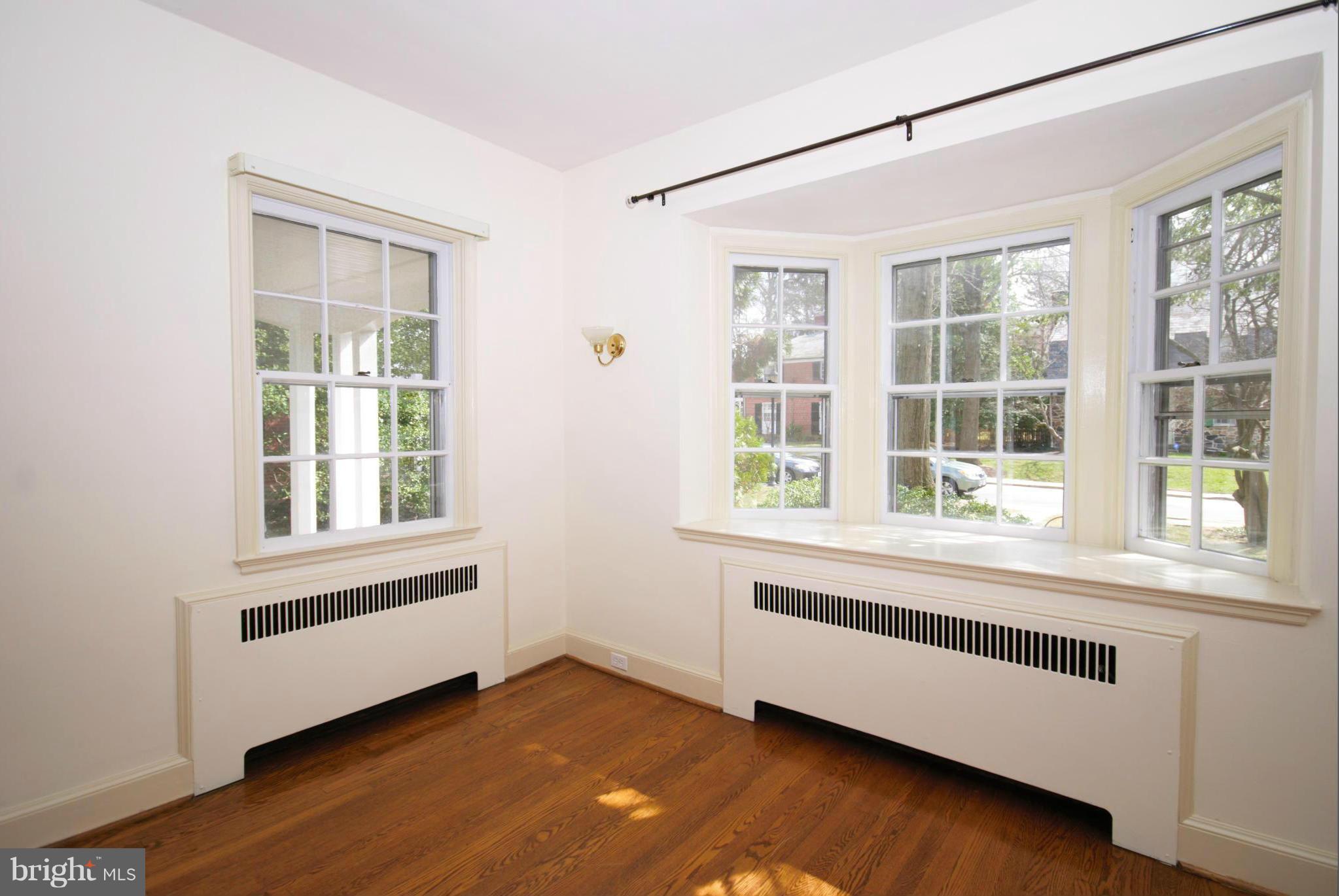 326 Paddington Road Baltimore, MD 21212 - Photo 9 of 29 a view of an empty room with a window and wooden floor