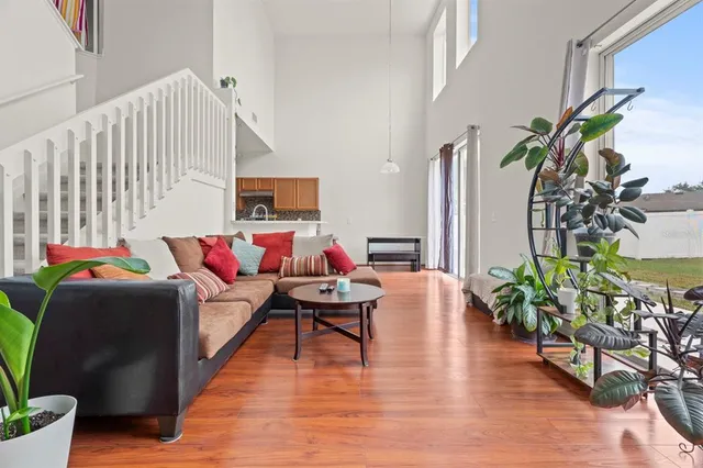 a kitchen with stainless steel appliances a sink a stove a refrigerator cabinets and a dining table with wooden floor