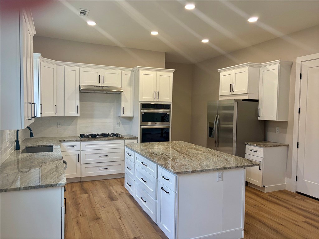 854 Perkins Creek Road Seneca, SC 29678 - Photo 8 of 34 Richly patterned stone countertops pair beautifully with crisp shaker cabinetry and warm hardwood flooring.