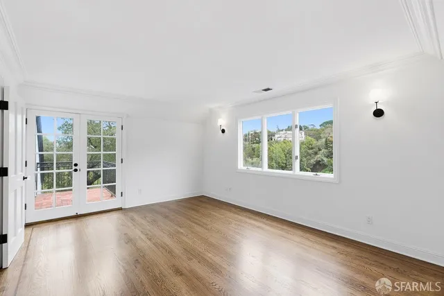a view of empty room with wooden floor and fireplace