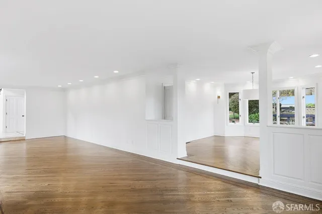 a view of empty room with wooden floor