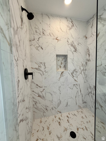 915 West Gold Ridge Ln Street St. George, UT 84790 - Photo 14 of 30 Shower enclosure featuring large format white marble-look wall tiles, matte black shower fixtures, a recessed niche, and a mosaic tile floor