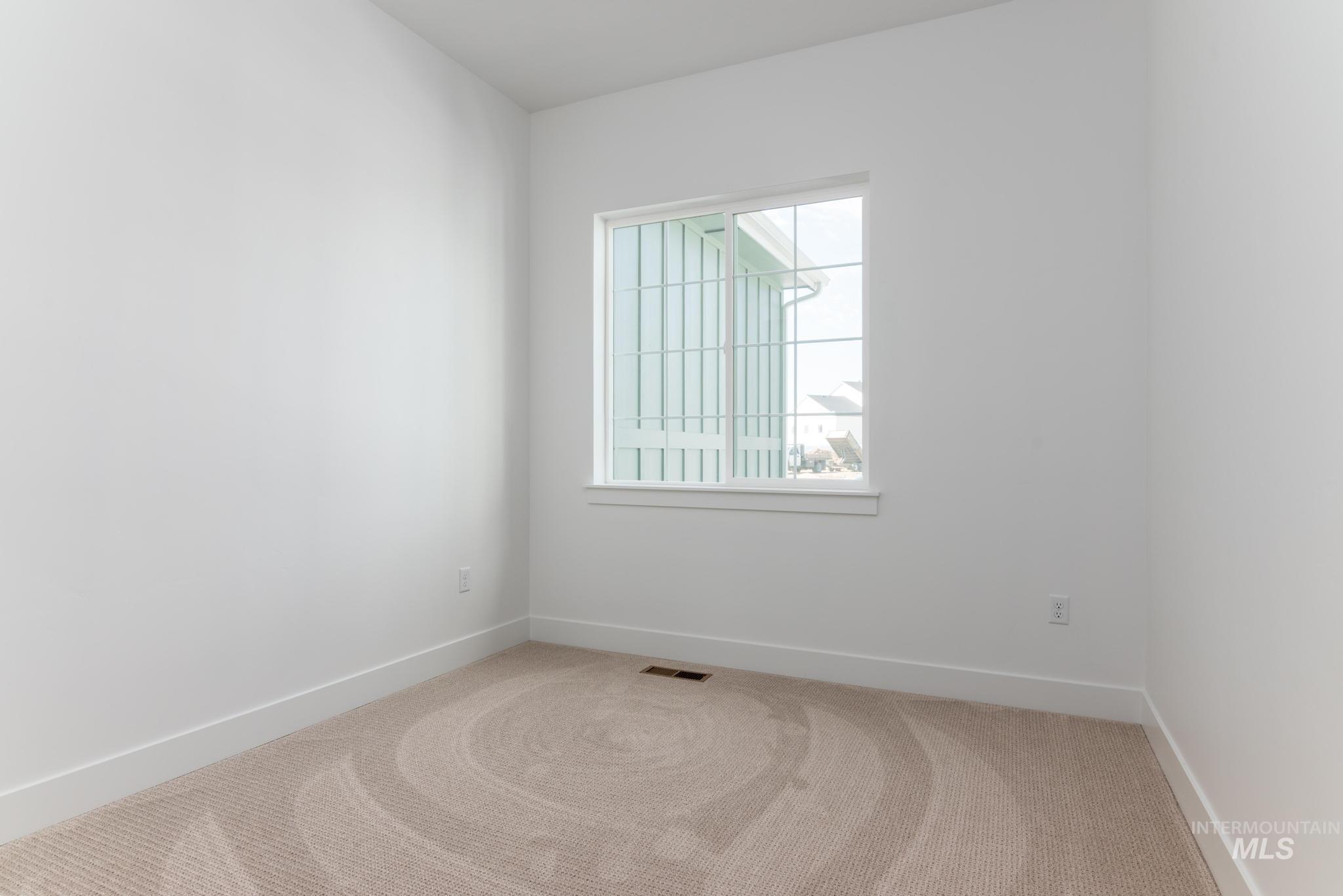 8558 South Silver Smog Way Meridian, ID 83642 - Photo 23 of 41 Bright room featuring a double-paned window, neutral carpeting, white baseboards, and a double-door closet with panel detailing