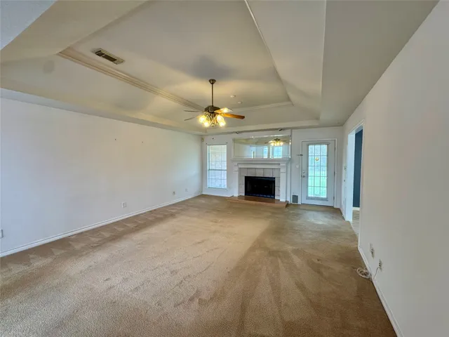 a view of empty room with a fireplace and fan