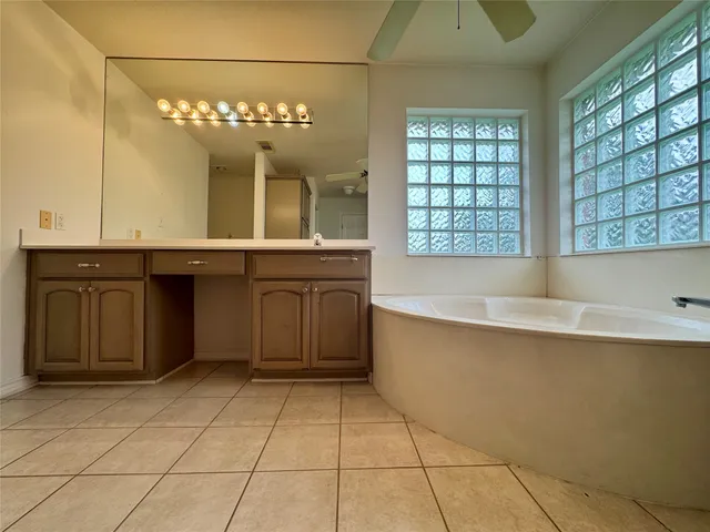 a large bathroom with a large tub and sink